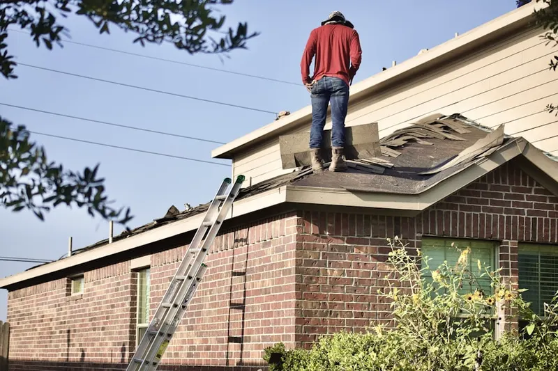 Professional roofer working on a residential roof in Davies Junction